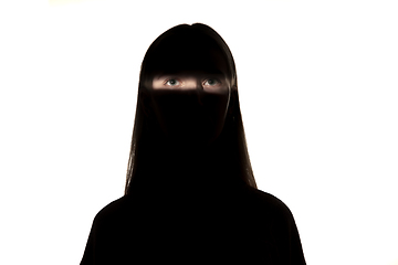 Image showing Dramatic portrait of a girl in the dark on white studio background.