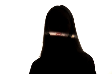 Image showing Dramatic portrait of a girl in the dark on white studio background.