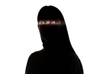 Image showing Dramatic portrait of a girl in the dark on white studio background.