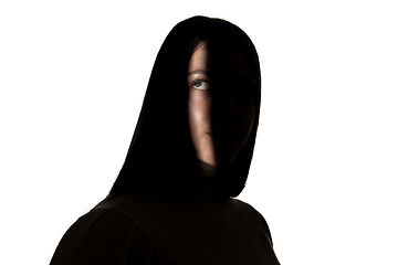 Image showing Dramatic portrait of a girl in the dark on white studio background.