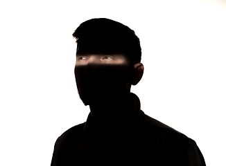 Image showing Dramatic portrait of a man in the dark on white studio background.