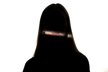 Image showing Dramatic portrait of a girl in the dark on white studio background.