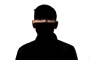 Image showing Dramatic portrait of a man in the dark on white studio background.