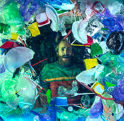 Image showing Man drowning in ocean water under plastic recipients pile, environment concept