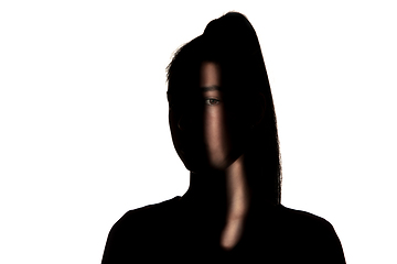 Image showing Dramatic portrait of a girl in the dark on white studio background.