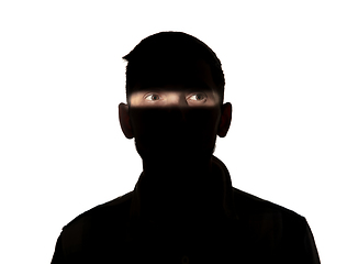 Image showing Dramatic portrait of a man in the dark on white studio background.