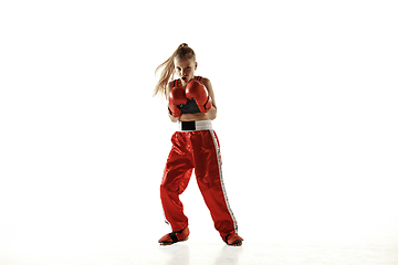 Image showing Young female kickboxing fighter training isolated on white background