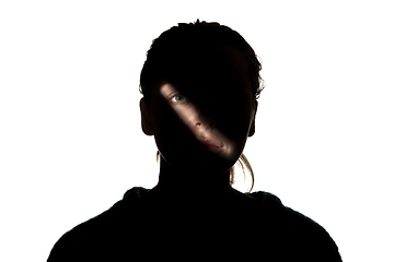 Image showing Dramatic portrait of a girl in the dark on white studio background.