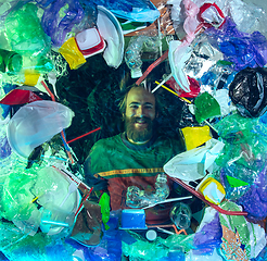 Image showing Man drowning in ocean water under plastic recipients pile, environment concept