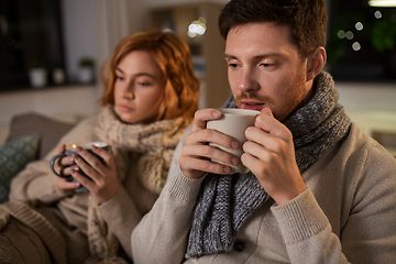 Image showing sick young couple drinking hot tea at home