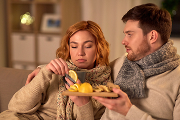 Image showing sick young couple drinking tea with lemon at home