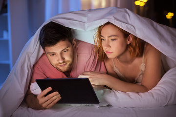 Image showing couple using tablet pc in bed at night