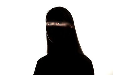 Image showing Dramatic portrait of a girl in the dark on white studio background.