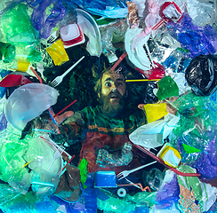 Image showing Man drowning in ocean water under plastic recipients pile, environment concept