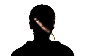 Image showing Dramatic portrait of a girl in the dark on white studio background.