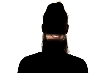 Image showing Dramatic portrait of a girl in the dark on white studio background.