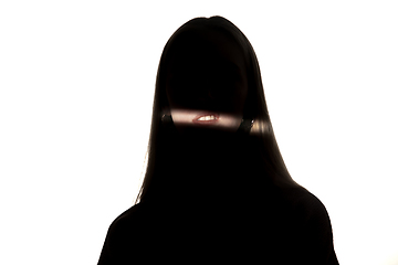 Image showing Dramatic portrait of a girl in the dark on white studio background.