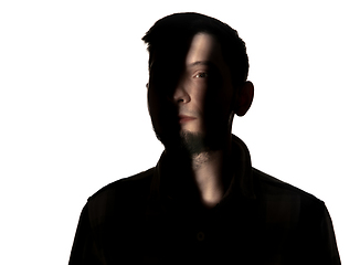 Image showing Dramatic portrait of a man in the dark on white studio background.