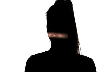 Image showing Dramatic portrait of a girl in the dark on white studio background.
