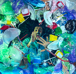 Image showing Man drowning in ocean water under plastic recipients pile, environment concept