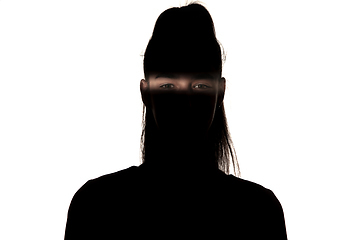 Image showing Dramatic portrait of a girl in the dark on white studio background.