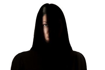 Image showing Dramatic portrait of a girl in the dark on white studio background.