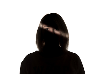 Image showing Dramatic portrait of a girl in the dark on white studio background.