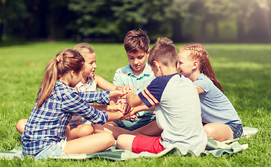 Image showing group of happy kids putting hands together