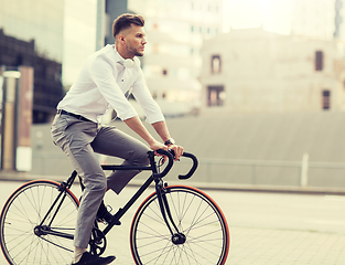 Image showing man with headphones riding bicycle on city street