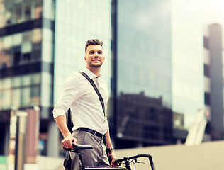 Image showing young man with bicycle on city street