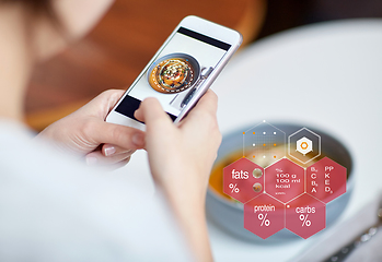 Image showing hands with phone and food nutritional value chart