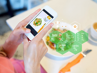 Image showing hands with food on smartphone screen at restaurant