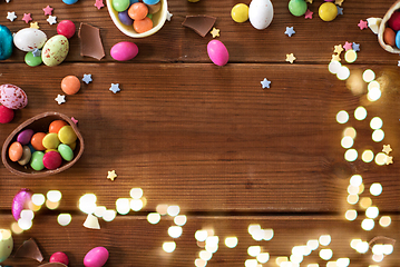 Image showing chocolate eggs and candy drops on wooden table