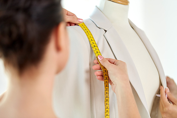 Image showing fashion designer measures jacket with tape measure