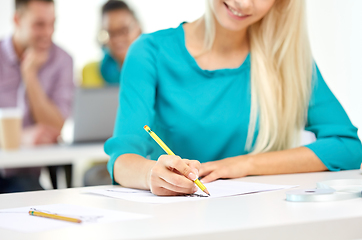 Image showing female fashion designer drawing sketch with pencil