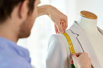 Image showing fashion designer measures jacket with tape measure