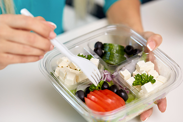 Image showing hands of woman eating take out food from container