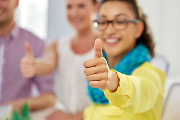 Image showing happy young woman showing thumbs up