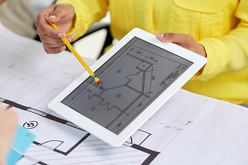 Image showing close up of architects with blueprint on tablet pc