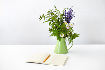 Image showing notebook with pencil and bunch of flowers in jug