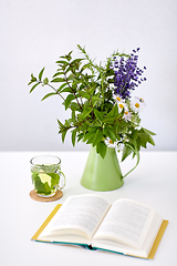 Image showing herbal tea, book and flowers in jug on table