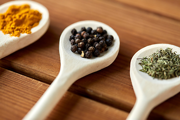 Image showing spoons with different spices on wooden table