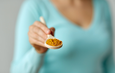 Image showing close up of woman with curry on wooden spoon