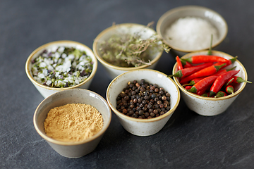 Image showing bowls with different spices on slate stone table