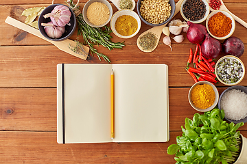 Image showing notebook with pencil among spices on wooden table