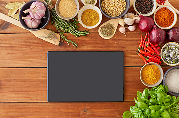 Image showing tablet pc computer among spices on wooden table