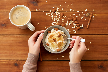 Image showing hands with oatmeal breakfast and cup of coffee