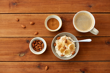 Image showing oatmeal with banana and almond on wooden table