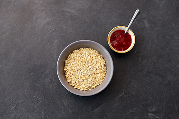 Image showing oatmeal breakfast and cup of fruit jam with spoon