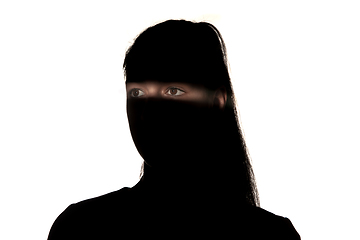 Image showing Dramatic portrait of a girl in the dark on white studio background.